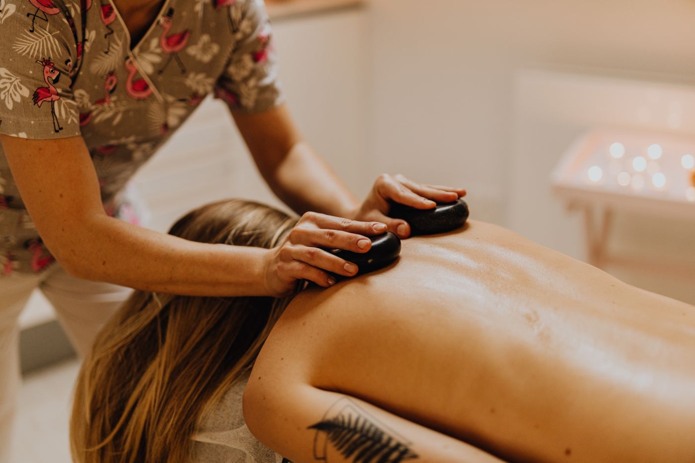 Therapist placing warm stones on the back in a hot stone massage in Dubai